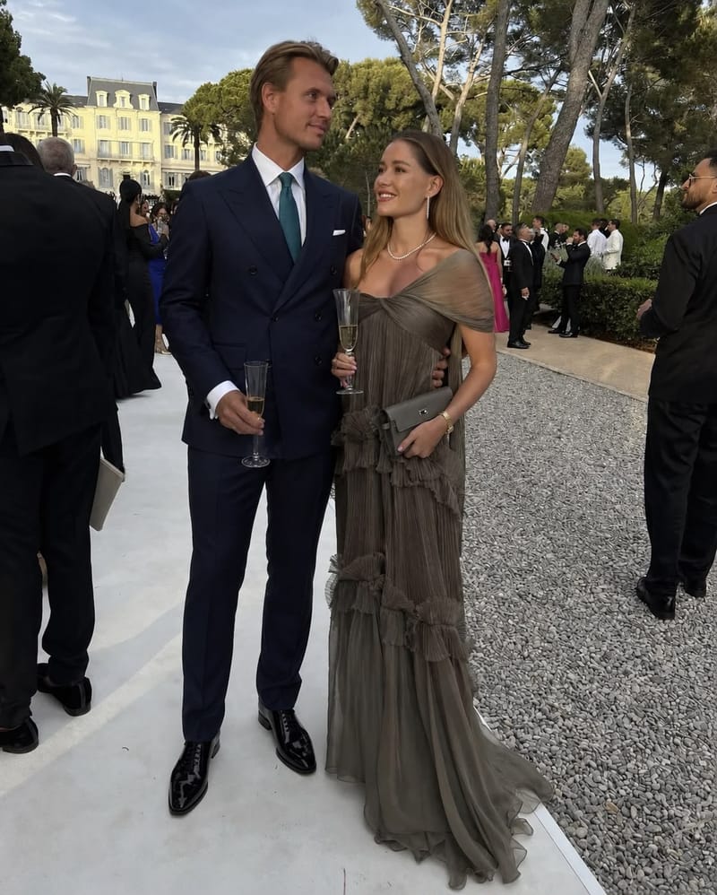 Formal wedding guests in long gowns and suits